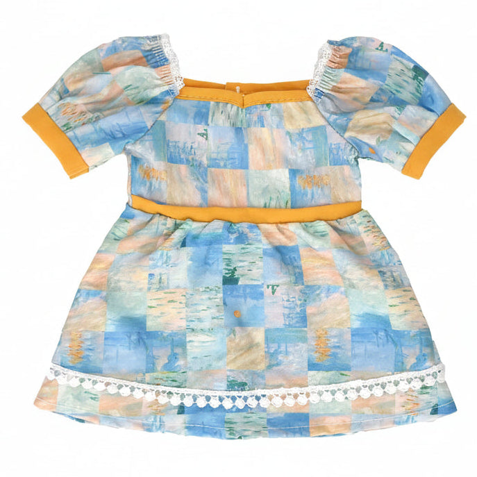doll dress with a colorful patchwork pattern and orange trim on a white background.